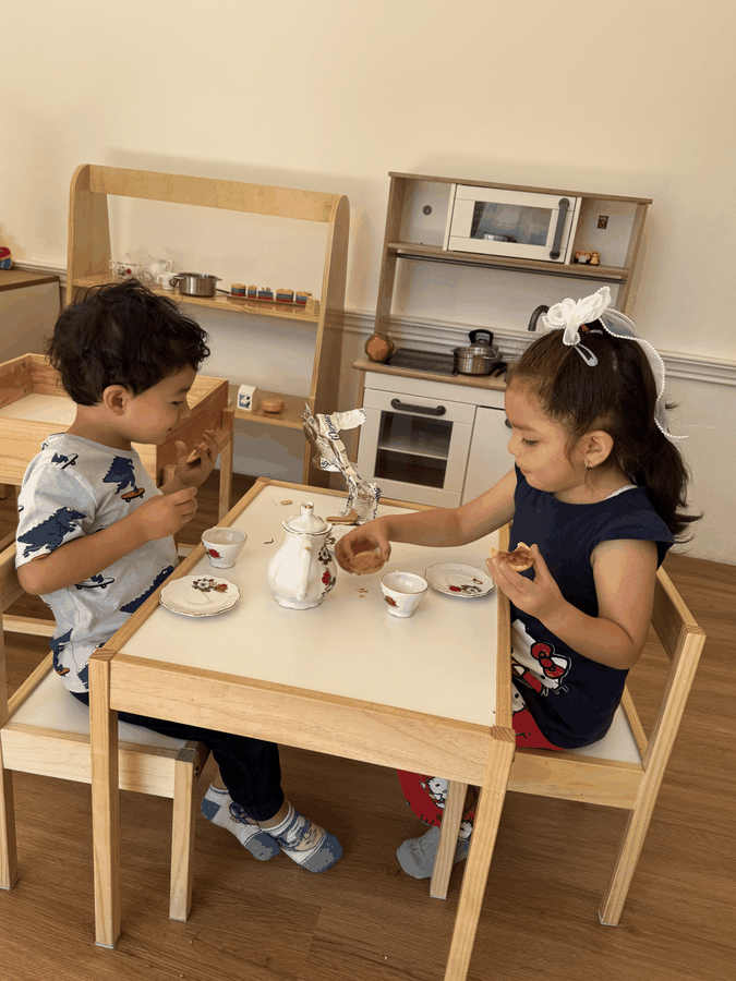 Niños jugando con una cocina de juguete